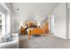 Bright bedroom boasts a wooden bed frame, plush carpet, and a comfortable white couch at 1867 W 137Th Ln, Broomfield, CO 80023