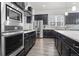 Modern kitchen with stainless steel appliances, mosaic backsplash, dark cabinets, and hardwood floors at 1867 W 137Th Ln, Broomfield, CO 80023