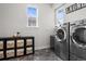 Functional laundry room with modern washer and dryer, storage cubbies, and bright windows at 1867 W 137Th Ln, Broomfield, CO 80023