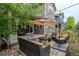 An outdoor patio with stylish wicker furniture, a fire pit, an umbrella, and ambient string lights at 1867 W 137Th Ln, Broomfield, CO 80023