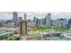 Panoramic aerial view of the city featuring urban rooftops, green spaces, and a backdrop of modern high-rise buildings at 2098 N Clarkson St, Denver, CO 80205