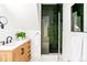 Modern bathroom boasts an emerald tiled shower, black fixtures, wood vanity and stylish mirror at 2098 N Clarkson St, Denver, CO 80205