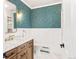 Stylish powder room with marble countertop, wood vanity, and patterned wallpaper at 2098 N Clarkson St, Denver, CO 80205