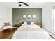 Cozy bedroom with green accent wall, and neutral-toned bedding at 2098 N Clarkson St, Denver, CO 80205