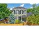 Charming two-story home with black shutters, a manicured front yard, and a privacy fence at 2098 N Clarkson St, Denver, CO 80205