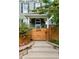 Inviting front entrance with steps leading to the covered porch, wood gate and colorful flowers at 2098 N Clarkson St, Denver, CO 80205