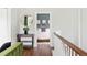 Upstairs hallway leading to bedroom with green accent wall and light wood frame at 2098 N Clarkson St, Denver, CO 80205