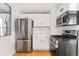 A modern kitchen with stainless steel appliances, white cabinets, subway tile backsplash and hardwood floors at 2098 N Clarkson St, Denver, CO 80205