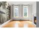 Bright living room featuring a fireplace, hardwood floors, tropical wallpaper and natural light from two large windows at 2098 N Clarkson St, Denver, CO 80205