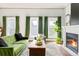 Sunlit living room with a modern fireplace, large windows, and stylish green velvet sofa at 2098 N Clarkson St, Denver, CO 80205