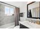 Modern bathroom featuring updated fixtures, a stylish mirror, and a shower-tub combo at 3902 S Uravan St, Aurora, CO 80013