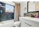Modern bathroom with a combination of dark and light tiles, a sleek white vanity, and a window with privacy glass at 3902 S Uravan St, Aurora, CO 80013