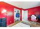 Vibrant bedroom with red walls, carpeted floors, and a closet, providing a comfortable space with ample storage at 3902 S Uravan St, Aurora, CO 80013