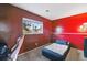 Bedroom with red walls and carpeted floors, with a window offering natural light and a view of the outdoors at 3902 S Uravan St, Aurora, CO 80013