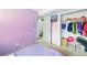 Bright bedroom with lavender walls, carpeted floors, and a closet, providing ample storage and a comfortable space at 3902 S Uravan St, Aurora, CO 80013