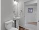 Bright bathroom with a pedestal sink, oval mirror, and wood-look flooring at 1086 Highlands Dr, Erie, CO 80516