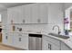 Modern kitchen features white cabinets, stainless steel dishwasher, and stylish subway tile backsplash at 1086 Highlands Dr, Erie, CO 80516
