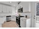 Modern kitchen featuring white cabinets, stainless steel appliances, and sleek countertop with black hardware at 1086 Highlands Dr, Erie, CO 80516