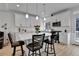 Modern kitchen boasts white cabinetry, stainless steel appliances, and a stylish island with pendant lighting at 1086 Highlands Dr, Erie, CO 80516