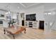 Bright living room features sleek entertainment center and bar stool seating at the kitchen island at 1086 Highlands Dr, Erie, CO 80516