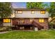Spacious backyard featuring a large deck, lush lawn, and mature trees for outdoor enjoyment at 7308 S Steele Cir, Centennial, CO 80122