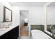 Modern bathroom showcasing a dual vanity, soaking tub, and open doorway to the bedroom at 7308 S Steele Cir, Centennial, CO 80122