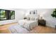 Comfortable bedroom features hardwood floors, a large window, neutral decor, and soft natural light at 7308 S Steele Cir, Centennial, CO 80122