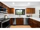 Bright kitchen boasts stainless steel appliances, wood cabinetry, and quartz countertops at 7308 S Steele Cir, Centennial, CO 80122