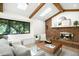 Inviting living room with a cozy fireplace, exposed beams, and ample natural light at 7308 S Steele Cir, Centennial, CO 80122