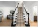 Elegant staircase featuring black and white accents, carpet runner, and views of the home's decor at 7308 S Steele Cir, Centennial, CO 80122