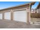 Individual garages with white doors and brown siding, providing private parking spaces for residents at 7440 S Blackhawk St # 2-106, Englewood, CO 80112