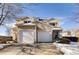 Tan two-story home with attached garage and snow-covered landscaping at 269 Ponderosa Pl, Fort Lupton, CO 80621