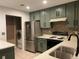 Modern kitchen with stainless steel appliances and green cabinets at 269 Ponderosa Pl, Fort Lupton, CO 80621
