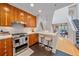 Modern kitchen featuring wood cabinets, stainless steel appliances, breakfast bar, and open layout at 1655 N Williams St, Denver, CO 80218