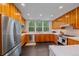 Well-lit kitchen showcasing stainless steel appliances, wood cabinets, and a view of the backyard at 1655 N Williams St, Denver, CO 80218
