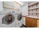Functional laundry room with a washer, dryer, sink, and ample shelving for storage at 1655 N Williams St, Denver, CO 80218