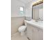 This bathroom features neutral tile and gray vanity with white basin and decorative mirror at 495 Quebec St, Denver, CO 80220