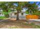 Cozy home featuring a stone and white painted exterior, a fenced yard, and lovely tree coverage at 495 Quebec St, Denver, CO 80220