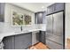 Charming kitchen features gray cabinets, stainless steel appliances, white subway tile, and views of the outdoors at 495 Quebec St, Denver, CO 80220