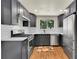 The kitchen features modern stainless steel appliances, gray cabinets, hardwood floors and bright, natural light at 495 Quebec St, Denver, CO 80220