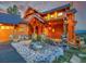 Close up of a stunning log home with inviting front entrance featuring stone accents and manicured landscaping at 29590 Buchanan Dr, Evergreen, CO 80439