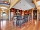 Expansive kitchen island with seating, stainless appliances, wood flooring, and stone accents in log cabin home at 29590 Buchanan Dr, Evergreen, CO 80439