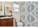 This bathroom offers a sink and vanity, toilet, window, decorative plant, and shower with curtain at 11089 Woodhurst Cir, Highlands Ranch, CO 80130