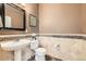 Stylish powder room with decorative tile accent and modern fixtures at 11089 Woodhurst Cir, Highlands Ranch, CO 80130