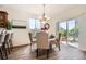 Elegant dining area with a modern chandelier, wood flooring, and a glass sliding door to the backyard at 11089 Woodhurst Cir, Highlands Ranch, CO 80130