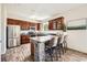 Spacious kitchen features stainless steel appliances, wood cabinets, and an island with seating at 11089 Woodhurst Cir, Highlands Ranch, CO 80130
