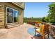 Relax on this beautiful concrete patio with stone wall, wooden chairs, and view of greenery at 11089 Woodhurst Cir, Highlands Ranch, CO 80130