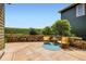 Relax on this beautiful concrete patio with stone wall, wooden chairs, and view of greenery at 11089 Woodhurst Cir, Highlands Ranch, CO 80130