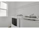 Bright laundry room features modern washer and dryer units and a wire shelf at 20826 Robins Dr, Denver, CO 80249