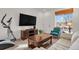 Comfortable living room featuring a big screen TV, wood coffee table, and a bright front window at 20826 Robins Dr, Denver, CO 80249